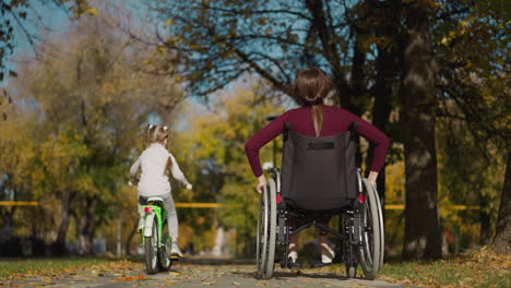 Mother-in-wheelchair-and-preschooler-enjoy-sunny-day-in-park