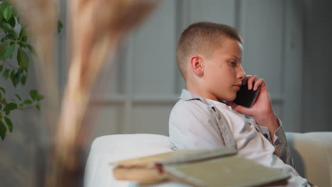 Boy-talks-on-smartphone-with-father-turning-head-to-side