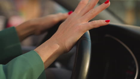 Woman-in-jacket-turns-steering-wheel-moving-fingers-to-music