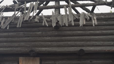 Remains-of-roof-of-wooden-house-after-fire-under-cloudy-sky