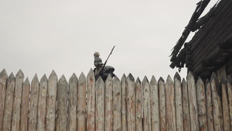 Evil-knight-with-spear-walks-near-burnt-house-behind-fence