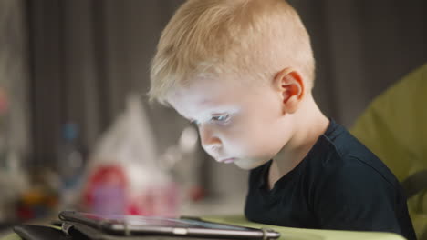 Little-boy-nods-head-watching-education-lesson-via-tablet