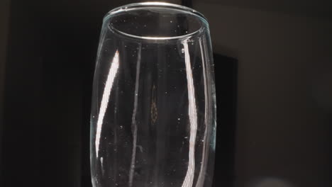 Transparent-champagne-glass-with-stains-on-dark-background