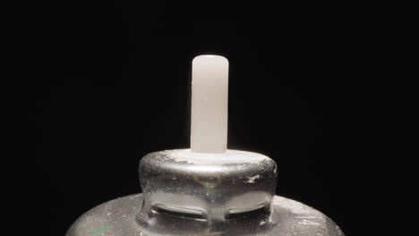 Plastic-tip-on-metal-cap-of-inhaler-bottle-shining-at-light