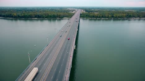 Beautiful-view-of-the-bridge-over-the-river-passing-cars-through-the-bridge-aerial