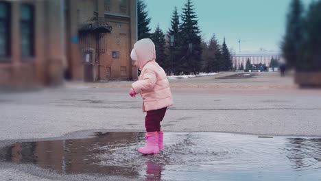 ittle-child-is-jumping-in-a-puddle-leaving-lot-of-spray