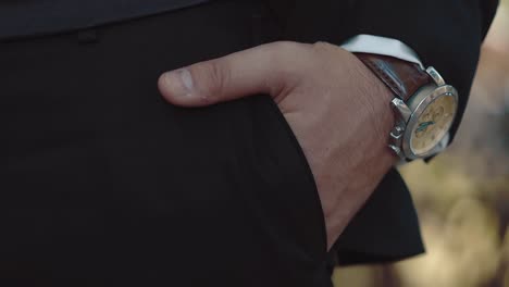 young-businessman-puts-his-hand-in-the-pocket-of-his-trousers-he-has-a-watch-on-his-hand-a-close-up-slow-motion