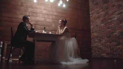 young-couple-in-a-wedding-attire-sitting-in-a-restaurant-and-talking-during-dinner-slow-motion
