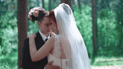 Newlyweds-hugging-standing-in-the-woods-close-up