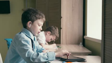 Kleine-Jungen-Machen-Ihre-Hausaufgaben,-Einer-Von-Ihnen-Zeichnet-Eine-Zeichnung-In-Ein-Notizbuch