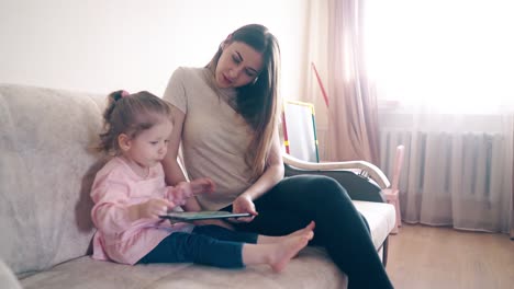 Mutter-Und-Tochter-Sitzen-Auf-Der-Couch-Und-Unterrichten-Mit-Einem-Tablet-Computer