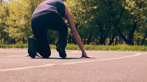 Back-view-Slow-motion-Young-cute-girl-sporty-physique-at-the-stadium-She-starts-running