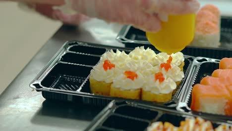 Der-Koch-Bereitet-Japanische-Brötchen-Mit-Einem-Gebratenen-Omelett-Zu-Und-Fügt-Roten-Kaviar-Lachs-Hinzu