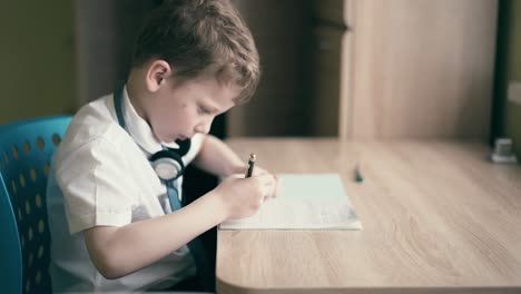 Child-sit-in-headphones-and-do-school-homework