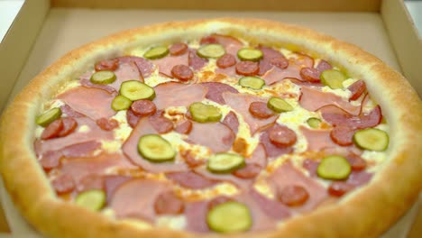 Koch-Legt-Gekochte-Pizza-Mit-Speck-Und-Geräucherter-Wurst-In-Eine-Kiste-Zur-Weiteren-Lieferung