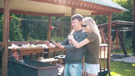 Travelling-Young-guy-with-a-girl-standing-near-the-barbecue-in-which-coals-are-smoking-2