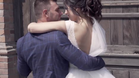 slow-motion-handsome-groom-lifts-bride-in-wedding-dress