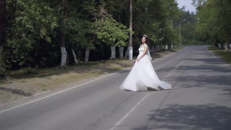 slow-motion-bride-in-long-white-dress-dances-on-road