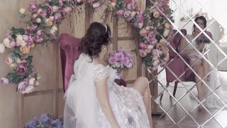 Die-Braut-In-Zeitlupe-Sitzt-Unter-Einem-Blumenbogen-Vor-Dem-Spiegel