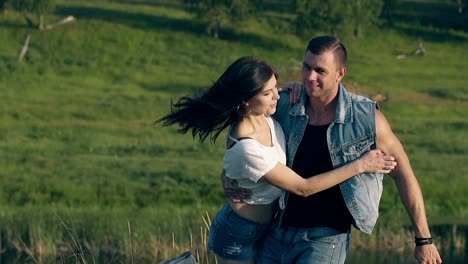 young-brunette-woman-jumps-in-handsome-muscular-man-arms
