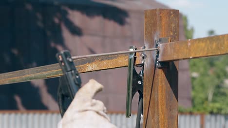 slow-motion-closeup-worker-welds-fence-metal-carcass