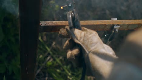 slow-motion-close-view-man-connects-fence-parts-by-welding