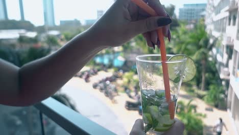 lady-relaxes-on-hotel-terrace-drinks-frozen-mojito-cocktail