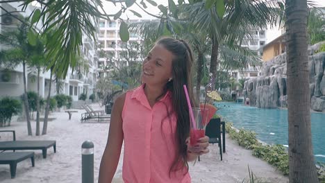 happy-woman-in-pink-blouse-walks-along-swimming-pool