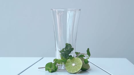 Glänzendes-Glas-Mit-Minzblättern-Steht-Auf-Weißem-Tisch