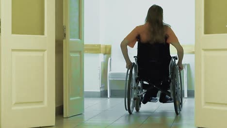 Junger-Mann-Fährt-Im-Rollstuhl-Durch-Einen-Krankenhausflur-2