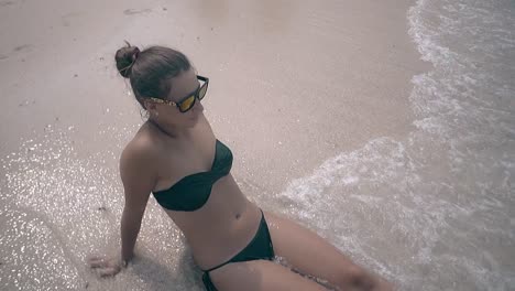 lady-in-bikini-lies-on-clean-sand-beach-and-enjoys-waves