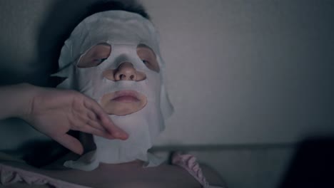 beauty-salon-visitor-in-white-regenerating-sheet-mask-close