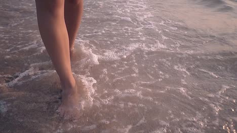 barefoot-lady-legs-walk-along-waves-on-shore-slow-motion