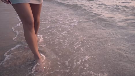 barefoot-girl-walks-along-running-waves-closeup-slow-motion