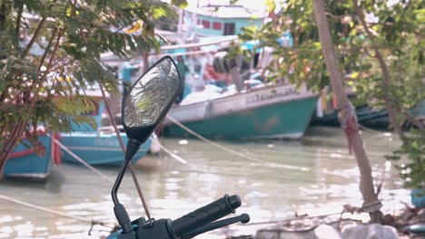 motorcycle-stands-against-people-working-with-fishing-net