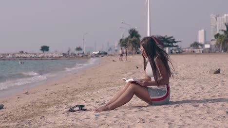 young-barefoot-woman-in-gray-summer-dress-reads-book