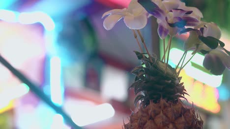 fresh-pineapple-with-flowers-against-shimmering-lights
