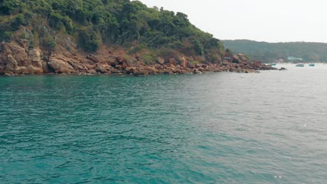 Impresionante-Vista-De-La-Isla-Verde-Mar-Azul-Claro-Y-Piedras-Marrones