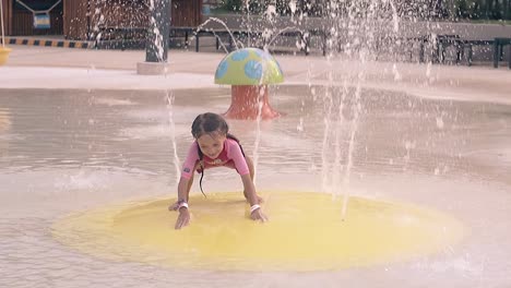 girl-closes-fountain-jets-by-hands-on-resort-slow-motion