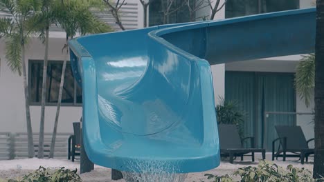 slide-with-flowing-water-at-resort-poolside-slow-motion