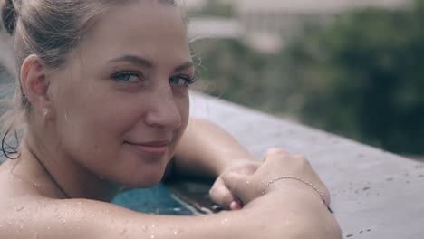 woman-with-perfect-skin-chills-in-blue-hotel-pool-water