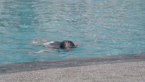 Junge-Dame-Mit-Braunen-Haaren-Schwimmt-Und-Taucht-Im-Poolwasser