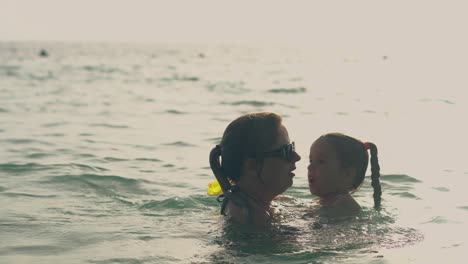 silhouettes-of-mother-and-daughter-swimming-in-ocean-water