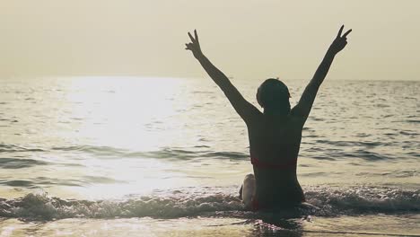 girl-silhouette-shows-Victory-gesture-at-ocean-slow-motion