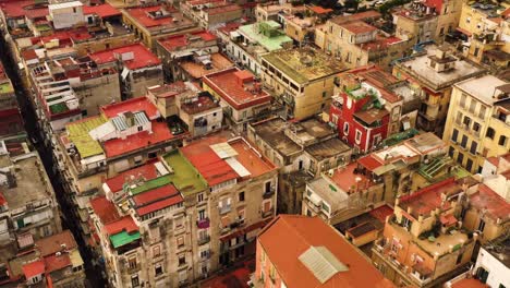Aerial-tilt-up-shot-showing-old-rusty-rooftops-of-apartment-blocks-during-golden-hour-in-Naples-City