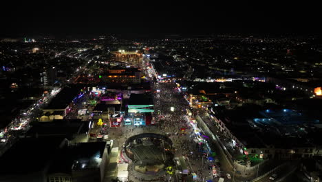 Aerial-overview-of-night-lit-street-at-the-San-Marcos-fair,-in-Aguascalientes,-Mexico
