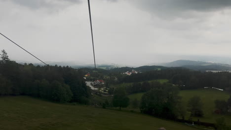 Aufsteigende-Gondel-Skilift-Fahrt-In-Österreich-In-Einem-Bergresort-Mit-Nebel-Im-Hintergrund
