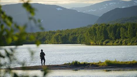 Silhouette-of-Fisherman-fishing-at-lake-Inari,-Finland,-At-Sunset