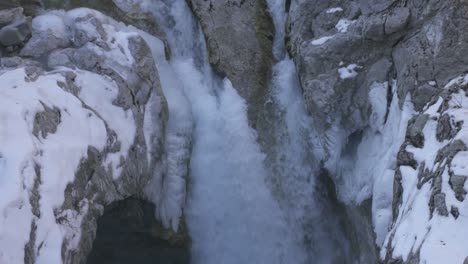 Wasserfall-In-Der-Riesigen-Gletscherschlucht,-Wasser-Fällt-Durch-Den-Rahmen-Mit-Schneebedecktem-Bergwandhintergrund