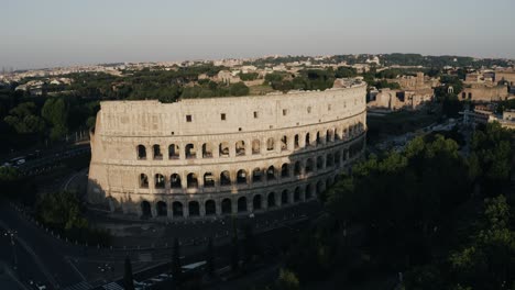 Vista-Aérea-Alejándose-Del-Coliseo-Romano-Con-Un-Pájaro-Volando